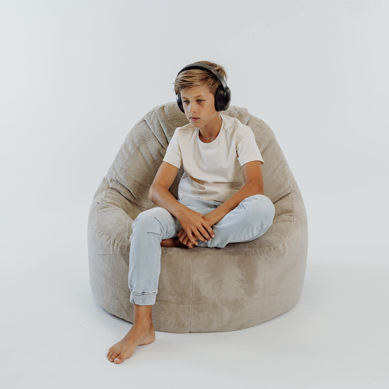 boy sitting on a large fur lounger bean bag