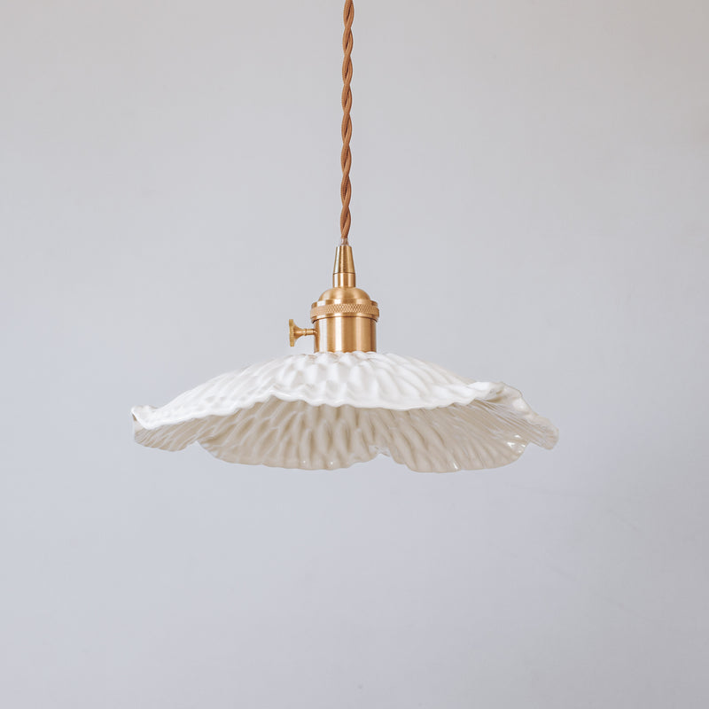 Pleated ceramic pendant light with brass gold fixture.