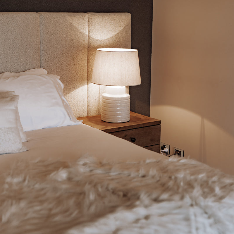 Quinn ceramic ribbed table lamp on bedside table.