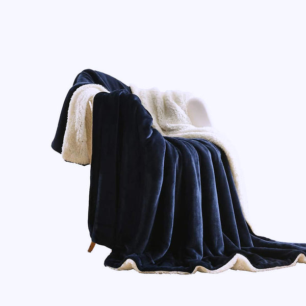 Plush navy blanket displayed on a sofa, adding a touch of elegance to the room's decor.