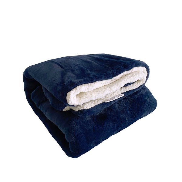 Plush navy blanket displayed on a sofa, adding a touch of elegance to the room's decor. 