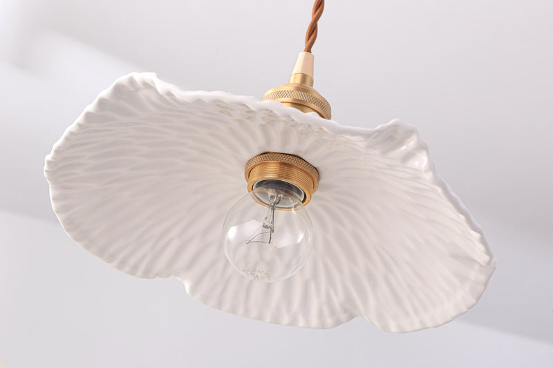 Pleated ceramic pendant light with brass gold fixture. 
