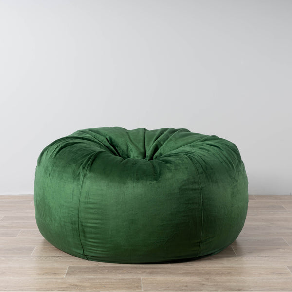 emerald green fur bean bag on a wooden floor