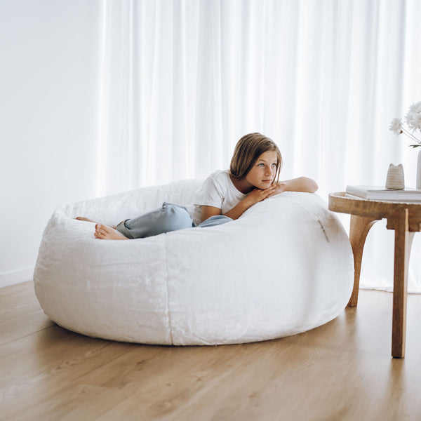 large white plush fur bean bag with young girl