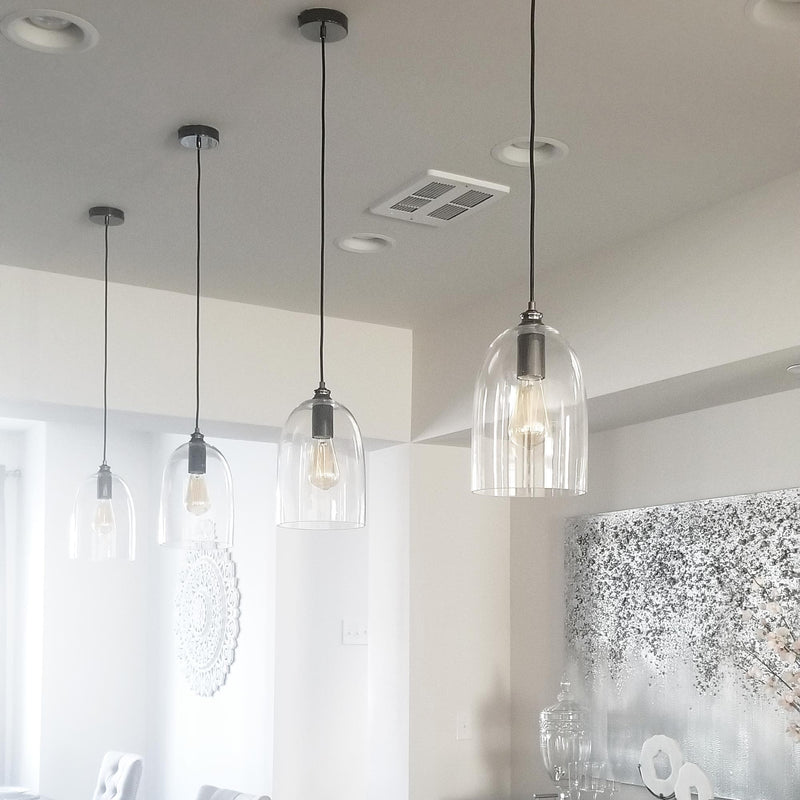 4 glass dome pendant lights with pearl black fitting and a filament globe hanging in a modern kitchen