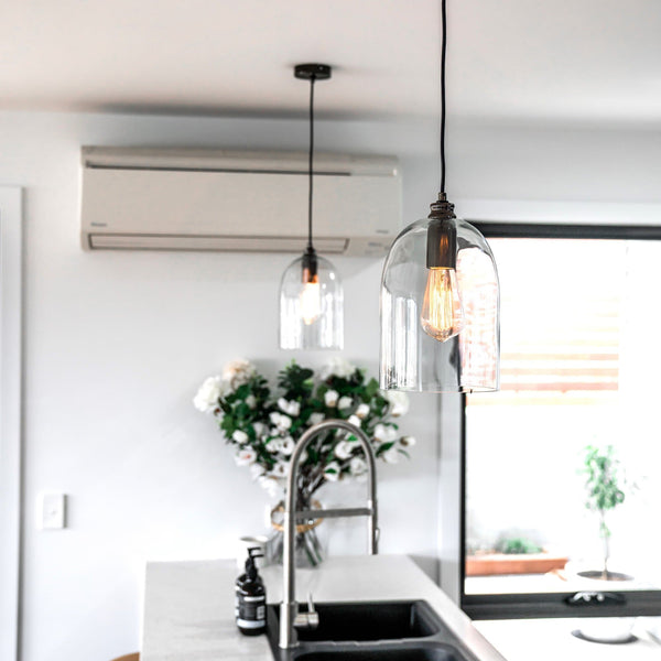 dome shape glass pendant light with pearl black fittings hanging in a modern kitchen