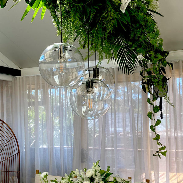 round glass pendant light with pearl black hardware hanging as a wedding display