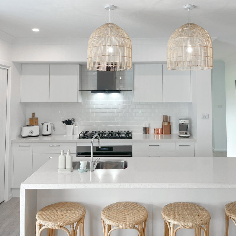 large rattan pendant light in a white kitchen with cane barstools