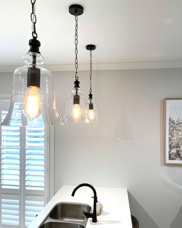 3 black gracie pendant light hanging in a white kitchen