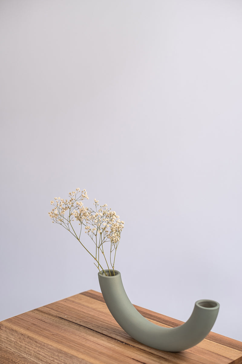 modern sage ceramic vase on a wooden shelf with dried flowers 