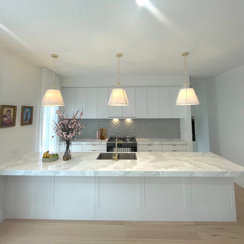 jessie pendant light with gold fittings and white shade in a white kitchen with marble benchtop