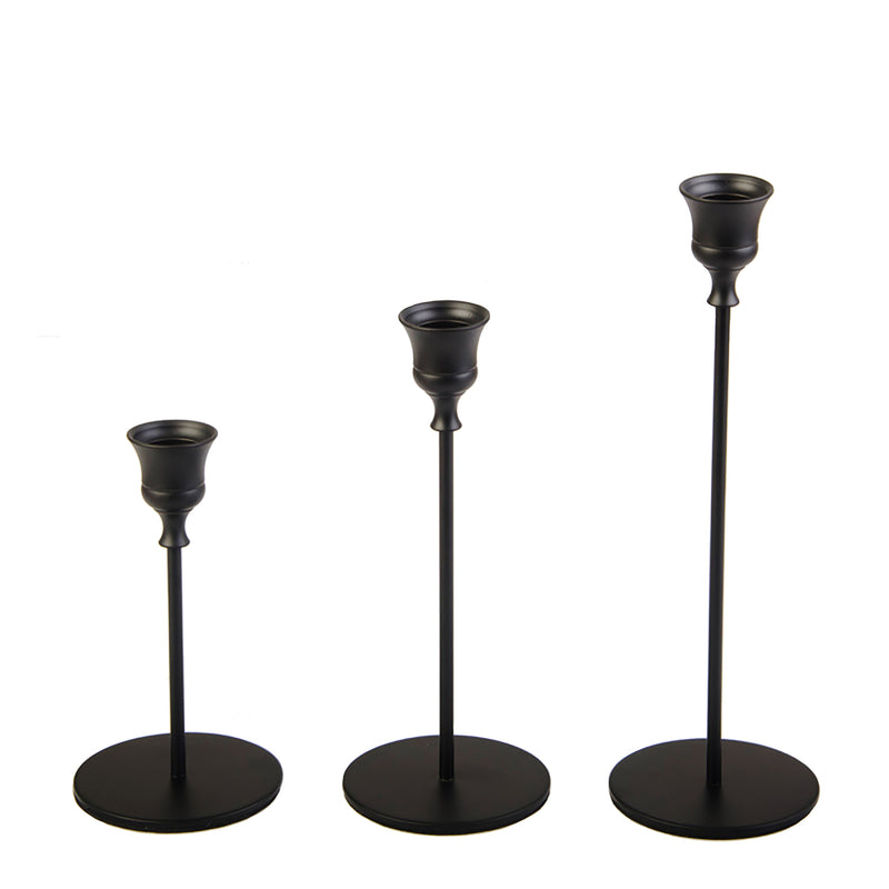 set of three elegant black candlesticks on a white background