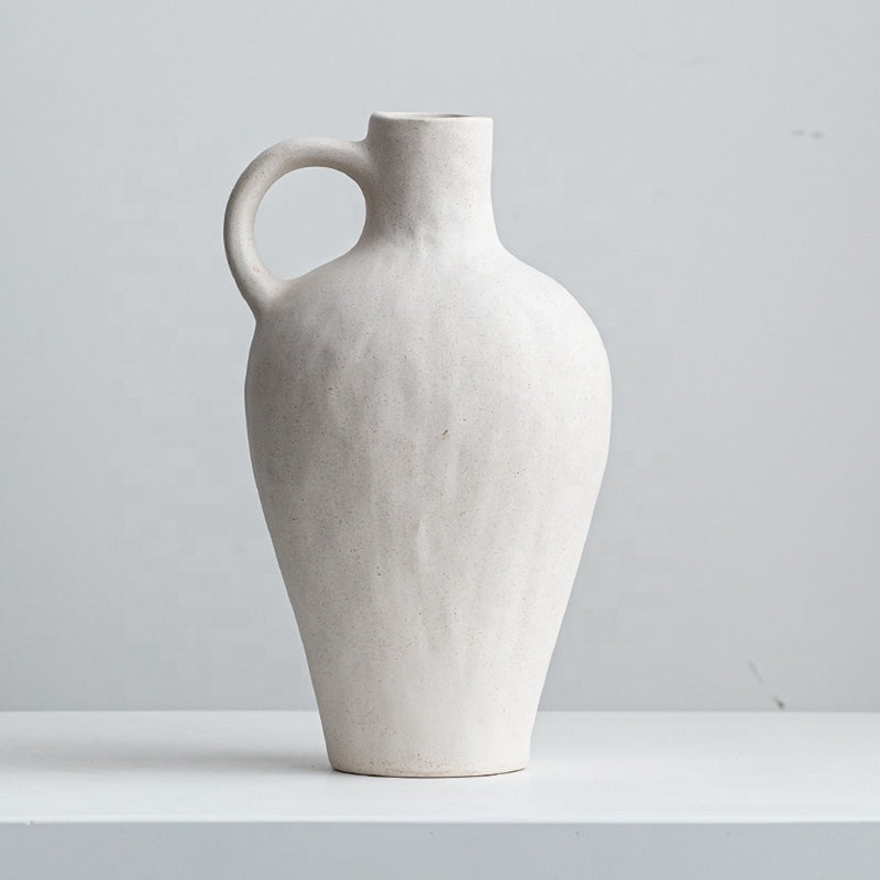 tall white vessel vase on white shelf