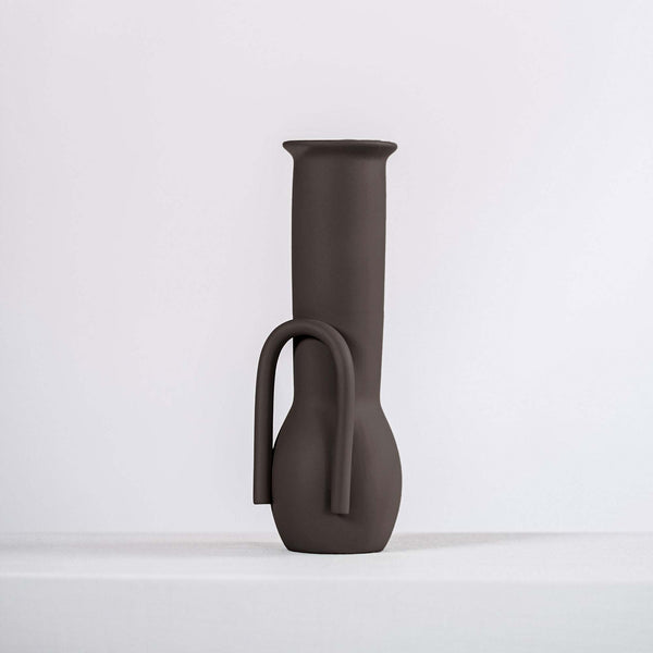 Black ceramic vase on a white shelf
