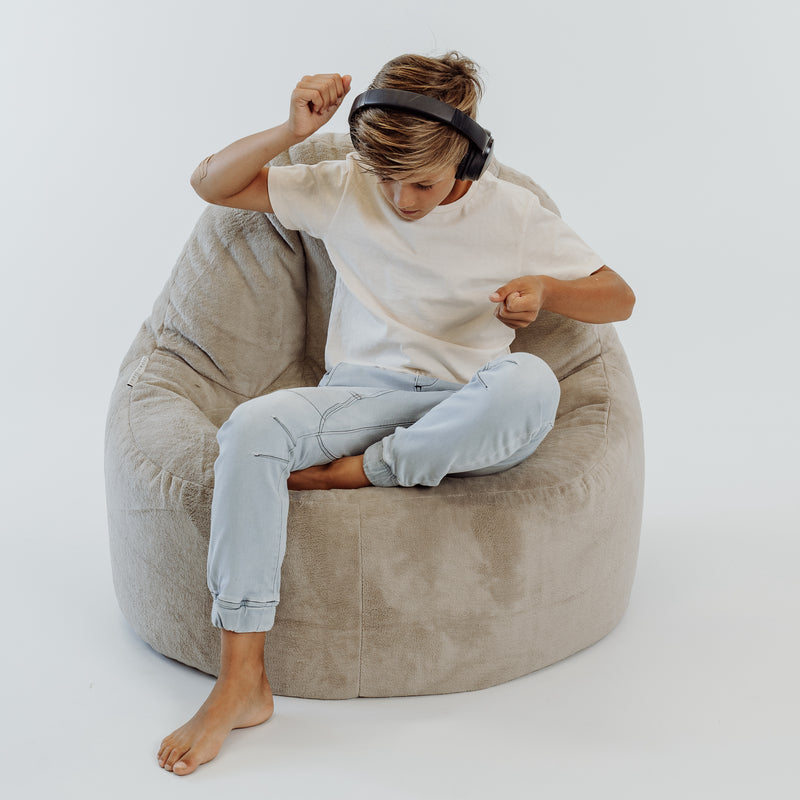 boy relaxing in a plush lounger fur bean bag  Edit alt text