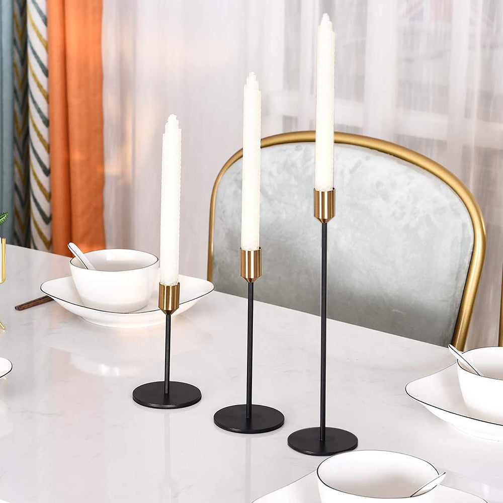 brass and black candlestick set on a white table
