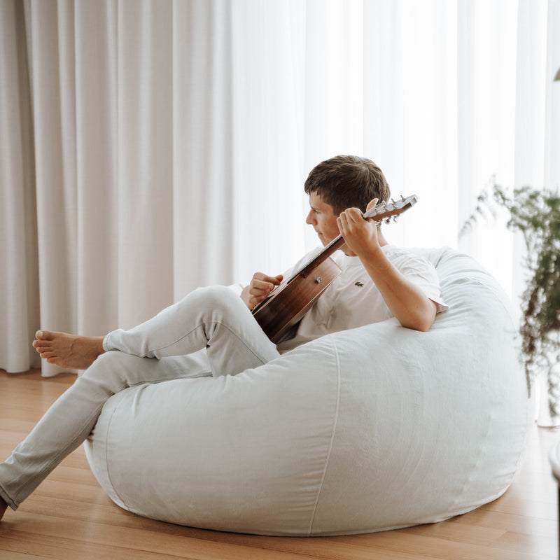large velvet fur beanbag with man relaxed playing a guitar